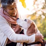 Woman embraces her dog outdoors Woman embraces her dog outdoors